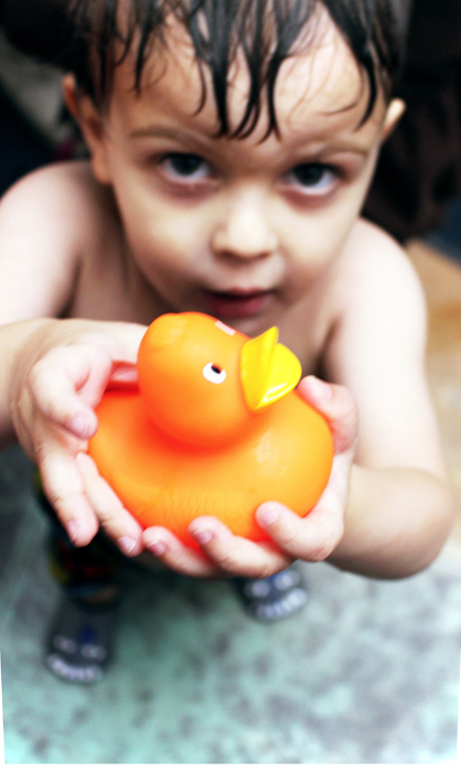boy holding toy duck in pool