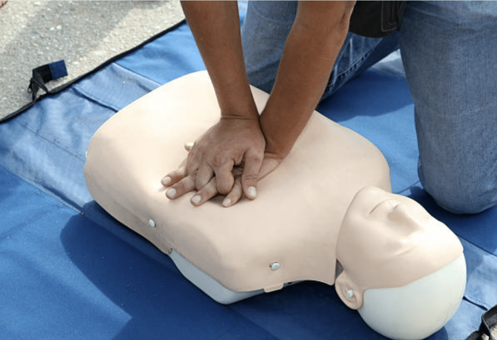 woman practices CPR on mannequin
